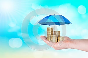Umbrella protection coins hand man holding stack of money savings a business. Protection money concept