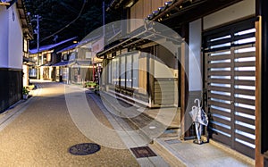 Umbrella stand and entryway to ryokan along empty street at night