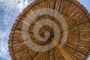 Umbrella from the sun from the reeds on the beach against the sky