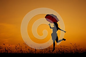 Umbrella woman jumping and sunset silhouette when she happy