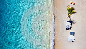 Umbrellas, Beach and ocean as a background from top view. Azure water background from top view. Summer seascape from air.