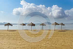 Umbrellas on the beach by the sea. La Manga del Mar Menor. Murcia, Spain