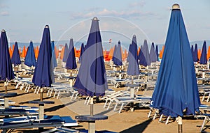 Umbrellas blue and orange in a sun-drenched Sea Beach
