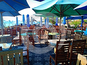 Umbrellas, chairs and tables in the outside restaurant are clean and ready for customers