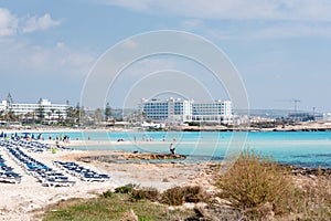 Umbrellas and chaise lounges on the beach. Plastic sunbeds near the sea. Tropical vacation, summer background.