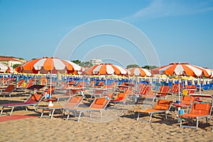 Umbrellas and chaise lounges on the beach of Rimini in Italy