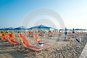 Umbrellas and chaise lounges on the beach of Rimini in Italy