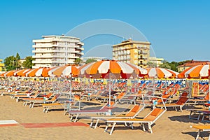 Umbrellas and chaise lounges on the beach of Rimini in Italy