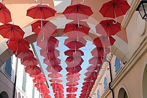 Umbrellas flying in sky over city street in Venice