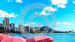 Umbrellas galore at Waikiki Beach with its many resorts under blue sky