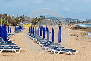 Umbrellas and sun loungers on the sandy beach at the beginning of the season. Ayia NAPA, Cyprus