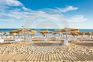 Umbrellas and sunbeds on the beach of Quarteira, Portugal, Algave