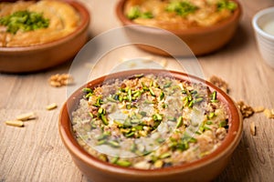 Umm sli topping with pistachio served in dish isolated on table top view of arabian food