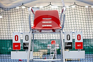 Umpire chair with scoreboard on a tennis court before the game.