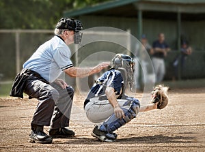 Umpire watches behind catcher as batter strikes