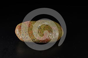 unakite mineral stone on black background