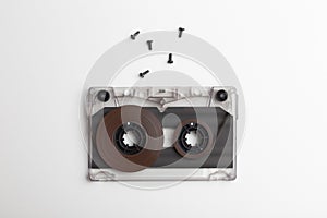 An unassembled compact audio cassette with screws