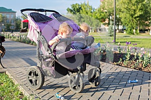 An unattended stroller with two children in city