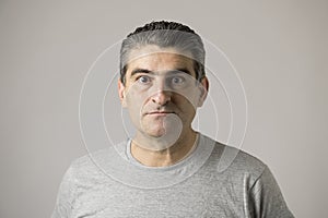 Unattractive 40s or 50s white funny man in sick and mad strange face expression isolated on grey background