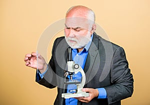 It is unbelievable. mature bearded teacher with microscope. senior man biologist. university professor. knowledge and