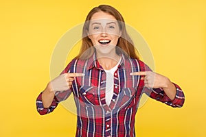 Unbelievable, this is me! Portrait of amazed proud ginger girl in checkered shirt pointing at herself and looking surprised