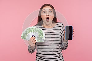 Unbelievable mobile banking application! Portrait of surprised shocked woman holding euro banknotes and cell phone