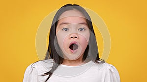 Unbelievable offer. Close up portrait of little stunned asian girl opening her mouth in amazement, being shocked