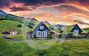 Unbelievable sunrise in icelandic countryside. Typical view of turf-top houses in Iceland