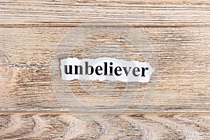 unbeliever text on paper. Word unbeliever on torn paper. Concept Image