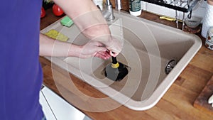 Unblocking the kitchen sink with vacuum apparatus, a person unblocks the sink with a vacuum