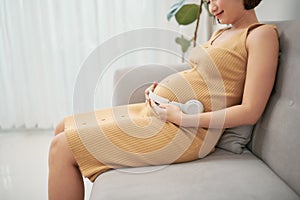 Unborn baby listening music in mother`s belly, copy space