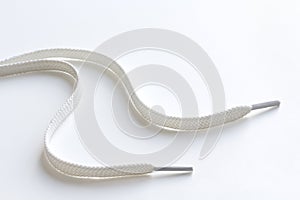 Unbound white shoe laces on white photo