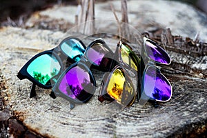 Unbranded colorful sunglasses on tree log