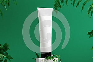 Unbranded container on shopfront. Plastic tube for toiletry. Tropical leaves on background. Flacon for professional cosmetics.