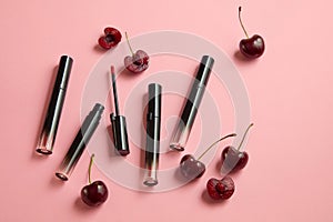 Unbranded lipsticks with fresh cherries decorated on a pastel pink background.