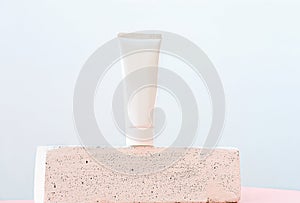 Unbranded white tube of cosmetic product on a pedestal or podium