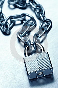 Unbreakable secure steel padlock and chain on steel surface