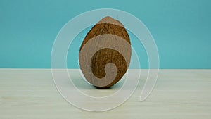 Unbroken coconut moves to the center of the frame, spins and goes away. Stop motion