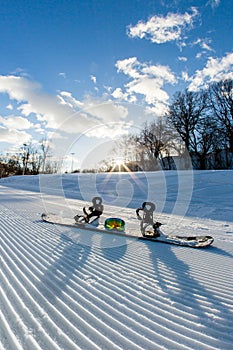 Unbroken ski slope, snowboard and goggles photo