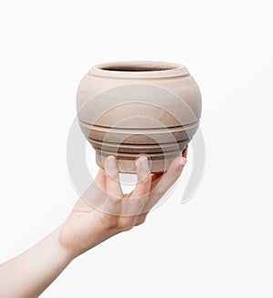 Unburnt clay pot in a woman's hand photo