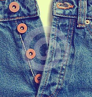 Unbuttoned blue jeans with metal buttons on a white background