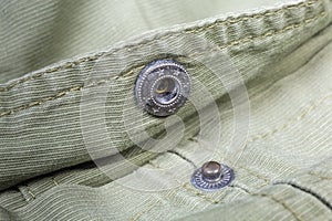 Unbuttoned snap button fastener on outerwear closeup in selective focus