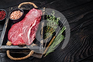 Unccoked rump steak or raw top sirloin beef meat steak. Black wooden background. Top view. Copy space