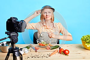 Uncertain young female chef looks aside with doubts, forgot new recipe