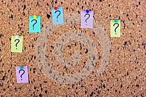 uncertainty or doubt concept, question mark on a sticky note on cork bulletin board