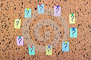 uncertainty or doubt concept, question mark on a sticky note on cork bulletin board