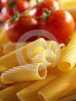 Unckoked pasta on white background with tomato photo