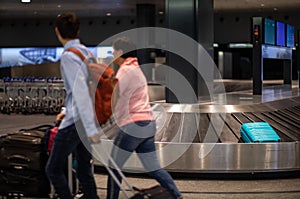 Unclaimed luggage concept - suitcase going around on the conveyor belt at an international airport, at the baggage claim zone -