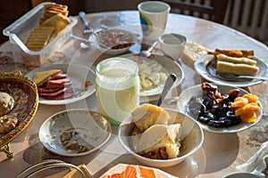 Uncleaned dining table with plates, mugs and food