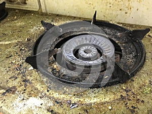 An uncleaned rusted dirty burned stainless steel top gas stove in house kitchen and Kitchen clean chemicals can clean this rubbish